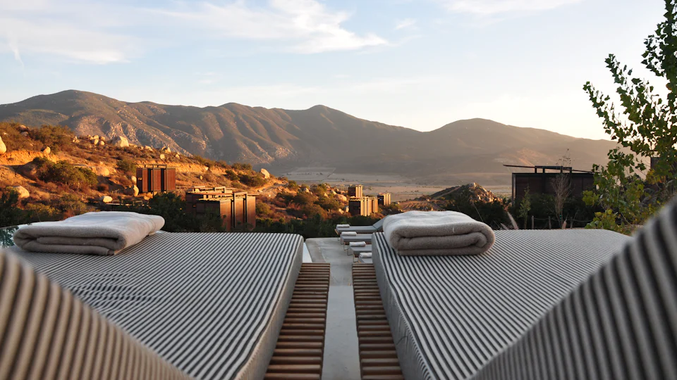 Sun loungers at a resort with mountains behind